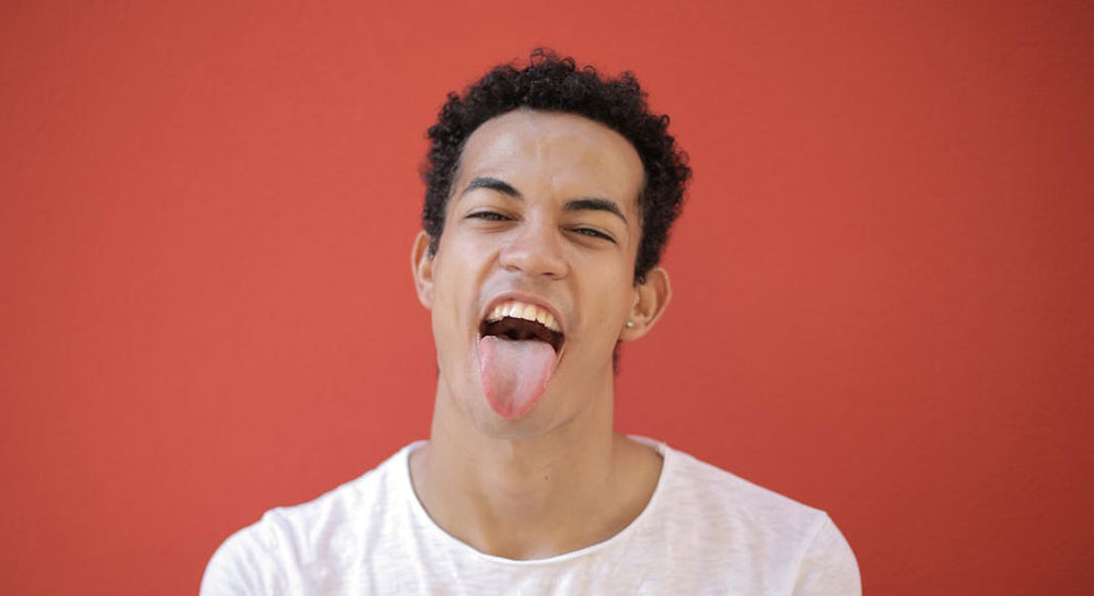 Young man with mouth open and tongue out, playful expression