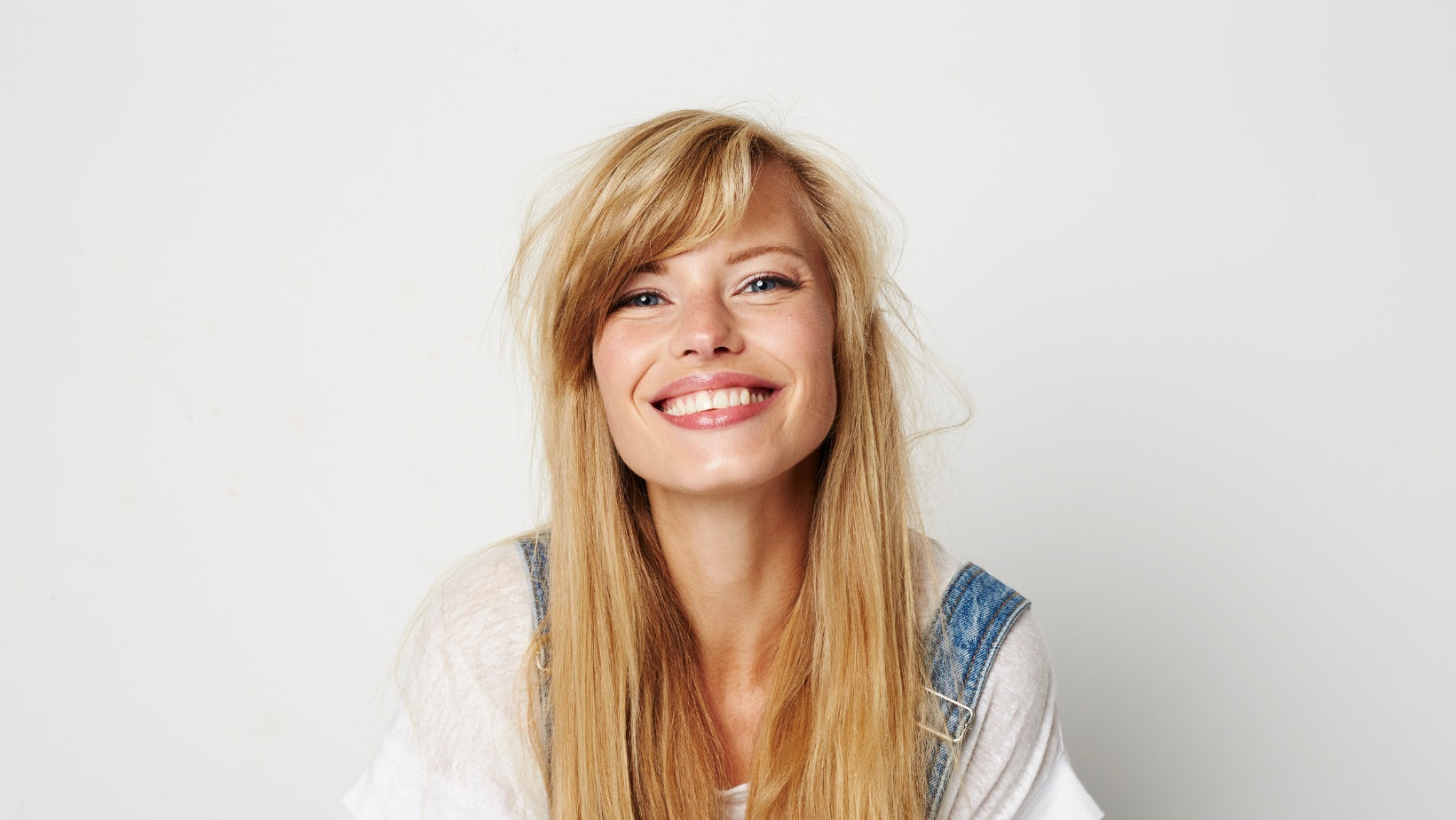 Blonde woman looking at the camera with a big happy smile