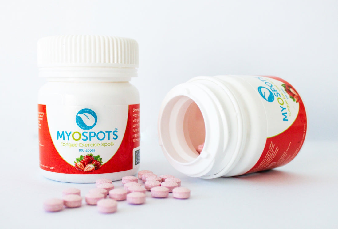 MYOSPOTS tongue exercise spot bottle with pink capsules on a white background