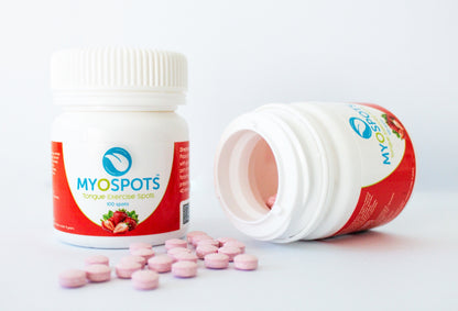 MYOSPOTS tongue exercise spot bottle with pink capsules on a white background